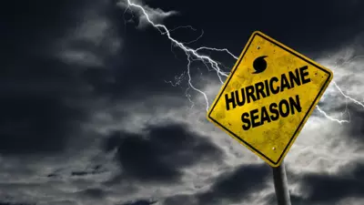 Dark stormy clouds and lightning bolt with yellow caution sign that reads Hurricane Season